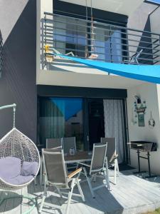 a patio with chairs and a table and a swing at Apartament Scandi N*.9 in Pobierowo