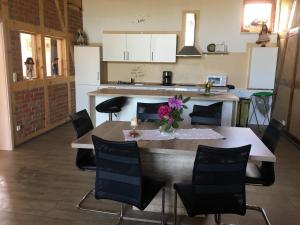 a kitchen with a table and chairs and a kitchen with white cabinets at Ferienwohnung Sültemeier 1 in Trebel