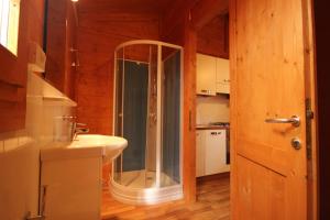 a bathroom with a glass shower and a sink at CAMPING CALATELLA parco di vacanza in Marina di Massa +67 photos