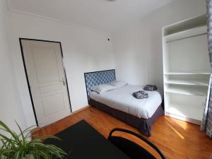 Dormitorio pequeño con cama y armario en NancyRoom en Vandoeuvre-lès-Nancy