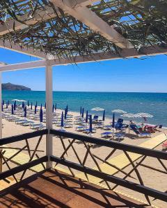 a beach with chairs and umbrellas and the ocean at Soleado Apartments Caprioli-Palinuro in Palinuro