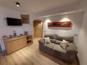 ein Wohnzimmer mit einem Sofa und einem Flachbild-TV in der Unterkunft Casa Rita in Tesero