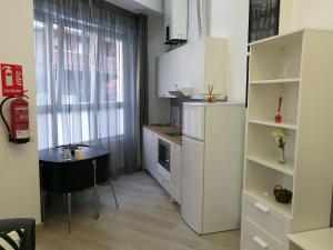 マドリードにあるL&G Madrid Apartmentsの小さなキッチン(小さなテーブル付)、小さなキッチン(白いキャビネット付)