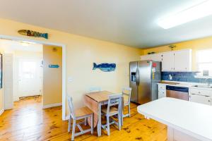 uma cozinha com uma mesa e cadeiras e um frigorífico em Two Views em Dauphin Island