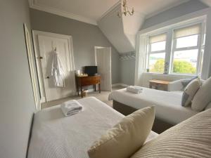 a bedroom with two beds and a window at The Old Rectory in Largs