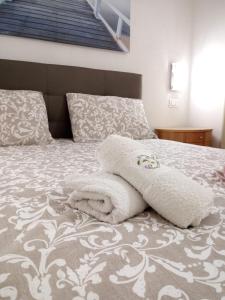 un letto con coperte bianche e cuscini sopra di Appartamento Antonia a Venezia