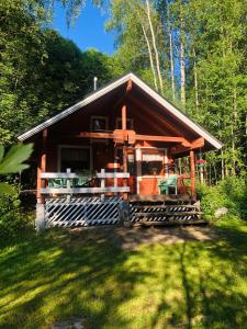 una cabaña en el bosque con un patio de césped en Pihlajamäen Lomamökit, en Vanhakylä