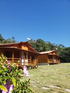 ein Haus mit einem Rasenplatz davor in der Unterkunft Pousada Gagno in Domingos Martins