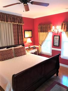 a bedroom with red walls and a bed with a ceiling fan at A Williamsburg White House Inn in Williamsburg