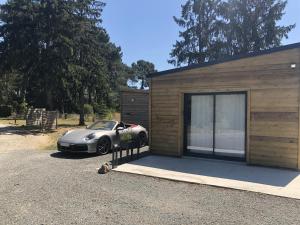 une voiture garée devant un petit garage dans l'établissement Cabane du Circuit, au Mans