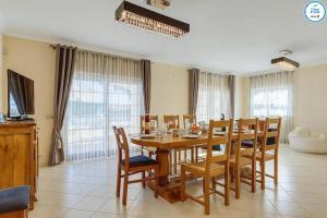 a dining room with a wooden table and chairs at Villa Mikael - Free Wi-Fi - Aircon - Private Pool by bedzy in Albufeira