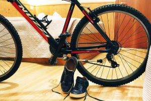 a bike parked in a bedroom next to a pair of shoes at Locanda Montegrappa in Borso del Grappa