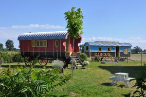 a train on display in a park with a bench at La roulotte CIRCUS des Grillots in Beaulon