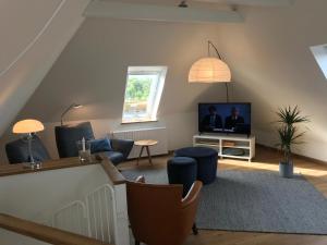 a living room with a couch and a tv at Moin ! in Timmendorfer Strand