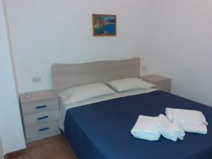 una camera da letto con un letto blu e asciugamani di La Casa di Lulu' a Palinuro