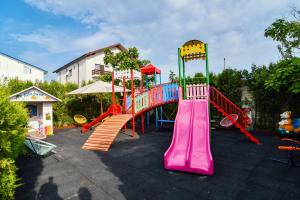 a playground with a colorful slide in a yard at Pensiunea Alfa in Mamaia Sat/Năvodari