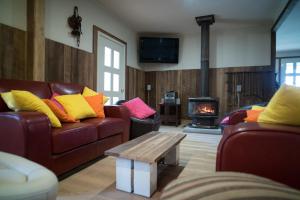 a living room with two couches and a fire place at Fentons Run Southern Highlands in Joadja Creek