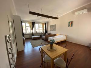 a living room with a table and a bed and a couch at P&J Apartamenty Grodzka in Kraków