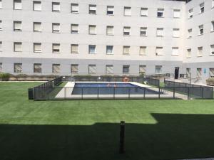 un edificio con una pista de tenis frente a un edificio en Apartamentos Apartour Bormujos, en Bormujos