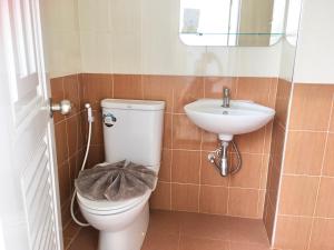a bathroom with a toilet and a sink at Boonbundal Hotel in Roi Et
