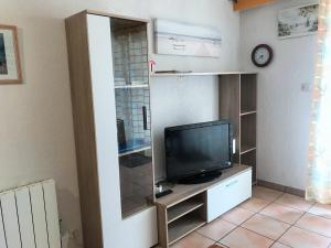 ein Wohnzimmer mit einem TV auf einem Schrank in der Unterkunft CONFORTABLE T2 EN FRONT DE MER, PARKING, WI-FI in Sète