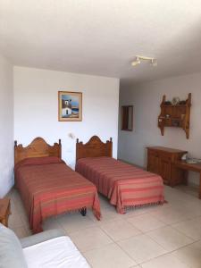 a bedroom with two beds and a table and a desk at Parque Santiago II Tenerife in Arona