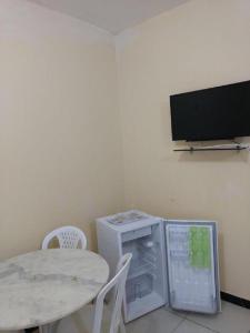 a kitchen with a table and a small refrigerator at Hotel Ibiapaba in Tianguá