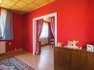 a living room with red walls and a wooden floor at Alluring Holiday Home in Meisdorf with Garden in Meisdorf