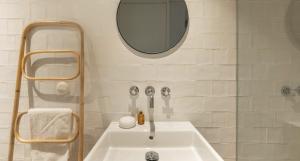 bagno bianco con lavandino e specchio di Cozy Lisbon Alfama a Lisbona