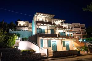 a large white building with lights on it at night at Theodora Rooms in Poros