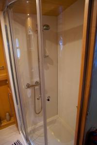 a shower with a glass door in a bathroom at Houseboat Hotels in Sheffield +5 photos