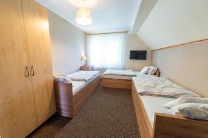 a room with two beds and a tv at Willa ATA Mikolajki in Mikołajki