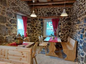 a dining room with stone walls and a table and chairs at B&B SognoInCadore in Domegge di Cadore