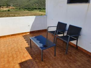two black chairs and a table on a patio at Hospedaria Firmino Bernardino in Odeceixe