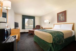 a hotel room with a large bed and a television at Travelodge by Wyndham Yampa in Yampa