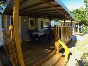 a wooden deck with a table and chairs on it at L europe in Vic-la-Gardiole