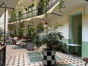 a courtyard with tables and potted plants in a building at Hotel Peninsular in Barcelona