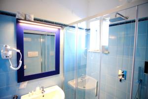 a bathroom with a sink and a shower with a mirror at Hotel Baia Di Puolo in Massa Lubrense