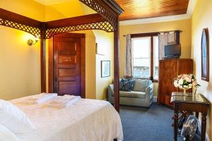 a bedroom with a bed and a couch and a window at The Sullivan House in New Shoreham