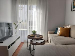 salon z kanapą i stołem w obiekcie Benamara Gardens, Apartment with Pool, 100m from Beach near Marbella & Estepona w mieście Estepona