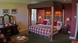 a hotel room with a bed and a mirror at Bunchrew House Hotel in Inverness