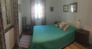 Un dormitorio con una cama verde y una ventana en 3 Bedroom Town House - Historic Centre of Cascais. 100 mts from the beach and centre of Cascais en Cascais