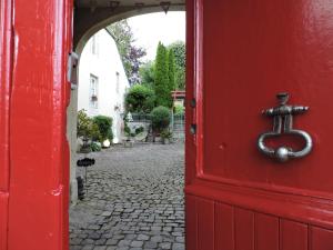 a red door with a metal letter t on it at La Closerie Teranga in Bayeux