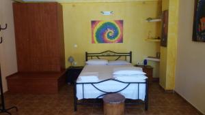 1 dormitorio con 1 cama y una pintura en la pared en Village Life Studio, en Kanakádes