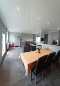 a kitchen and dining room with a wooden table and chairs at Vakantiehuis 't Wijngaardje in Merkem