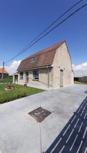 a white brick building with a red roof at Vakantiehuis 't Wijngaardje in Merkem