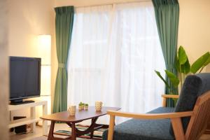 a living room with a tv and a chair and a table at Ryoshi Minpaku CHOUTA - Vacation STAY 7955 in Awaji