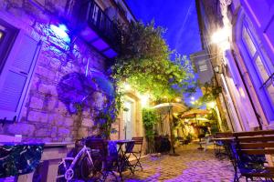 an alley with tables and chairs and a building with purple lights at Rue d'Azur Alaçatı in Alaçatı
