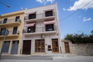 un edificio bianco con finestre e balcone di Casa Vacanza Barone a Castellammare del Golfo