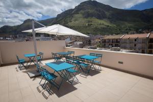 a patio with tables and chairs and an umbrella at Casa Vacanza Barone in Castellammare del Golfo